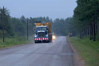 Killaloe, Ontario / Kanada - 31 Temmuz 2020: Kütük taşıyan tomruk kamyonu, Turners Yolu 'ndan aşağı gidiyor. Yağmurlu bir sabahta 