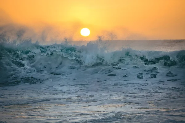 Beautiful storming ocean wave against sunset, sea water in rough shape