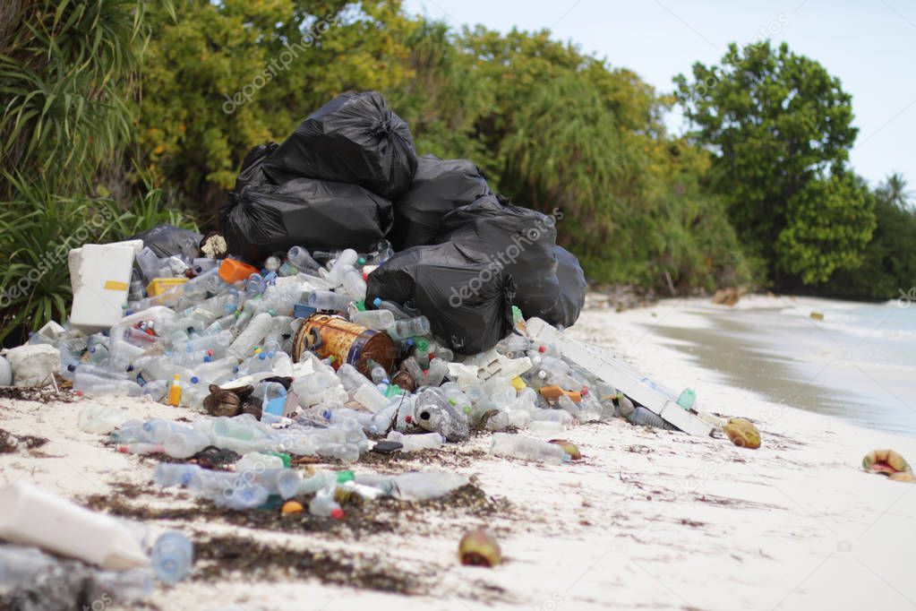 Plastic garbage on tropical white sand beach among mangrooves by sea water 
