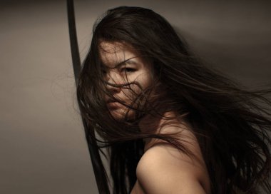 Katana kılıç tutan akan saç ile Oryantal kız arka planda copyspace ile assasin görme bakıyor