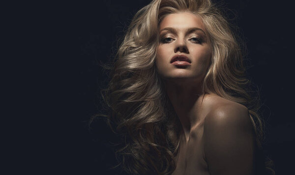 Блондинка, студийный портрет, голова в технике низкого ключа, копирайт на темном фоне
