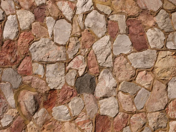 Photograph of colored stones in a stone wall background and texture