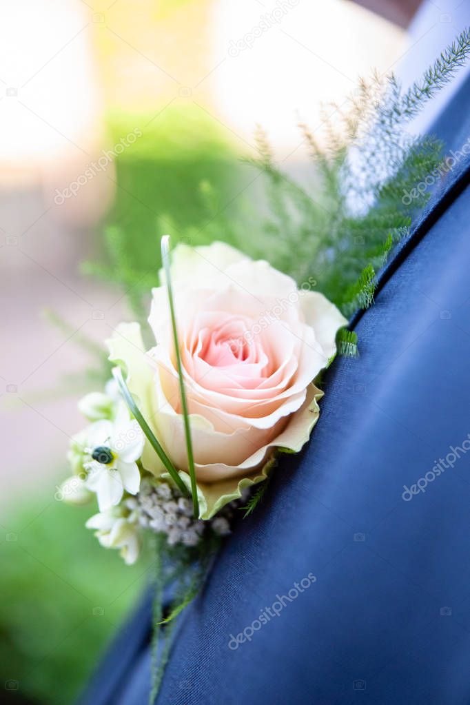 Cheerfully made up corsage with bright flowers. Groom with floral ornament for a wedding. Traditional wedding details for bride, brides sum and guests