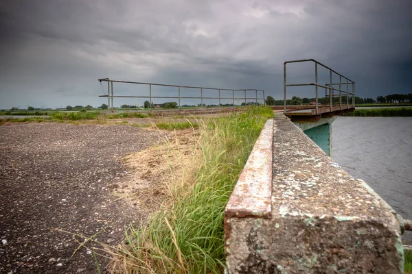 Eski ve harap vintage sur boyunca waterfront bir nehir landaschap Hollanda'nın içinde. Terk edilmiş durumda beton bağlama İskelesi.