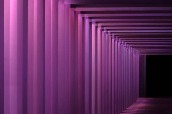Details of a viaduct during a Night scene with an urban city look. Different colors illuminate tunnel.