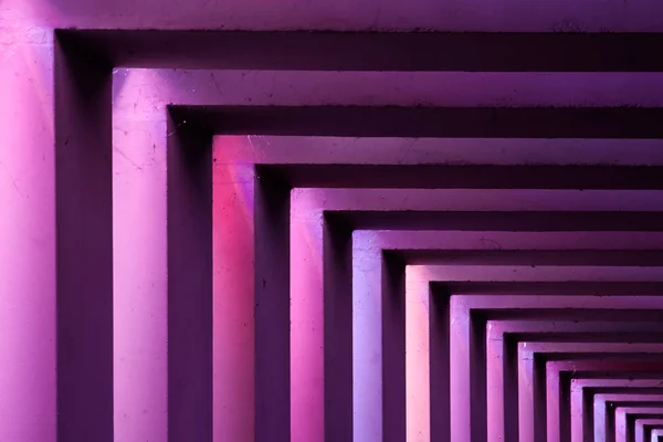 Details of a viaduct during a Night scene with an urban city look. Different colors illuminate tunnel.