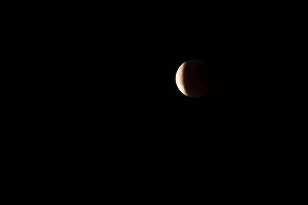 Moon in the starry sky with a blood red color as a result of a lunar eclipse through the earth.