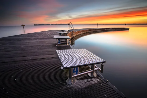 木製の板 朝露とカラフルな日の出と長い桟橋湖で美しい朝 — ストック写真