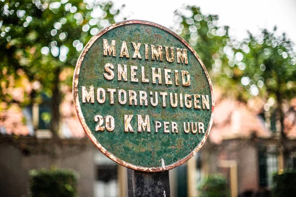 Old vintage dutch language road sign of iron with green patina and rust