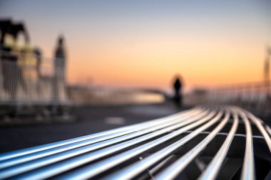 Modern boş demir tezgah ile eğri şekiller bir Bulvarı boyunca ya da bir parkta. Alüminyum renkler ve deniz feneri arka arka plan bulanık