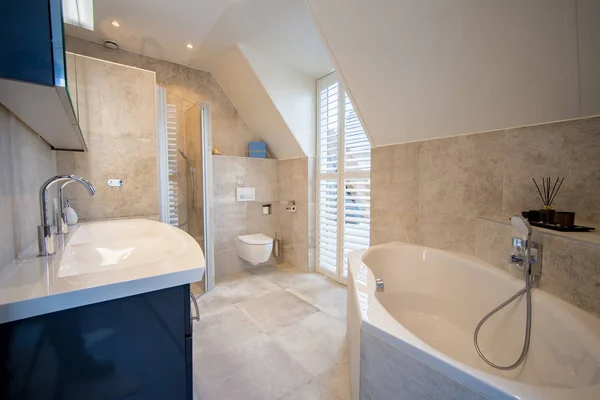 Architecturally built bathroom with luxury tiling, white shutter