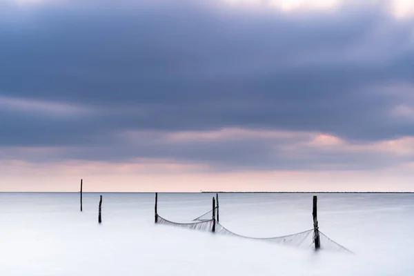 Fishing nets in a large lake during twilight with sunset colored — Stock Photo, Image