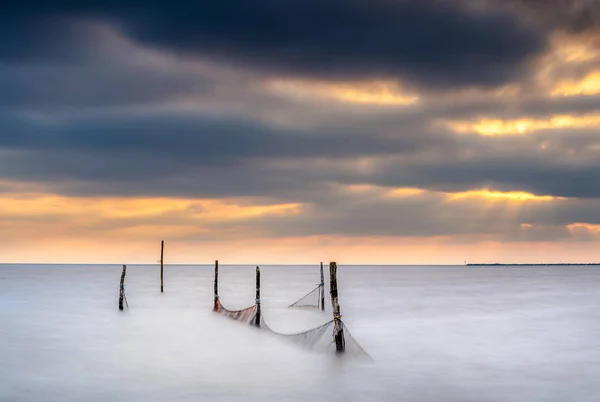 Fishing nets in a large lake during twilight with sunset colored — Stock Photo, Image