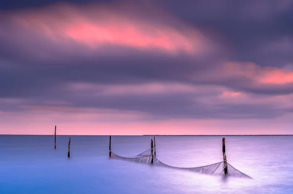 Fishing nets in a large lake during twilight with sunset colored — Stock Photo, Image