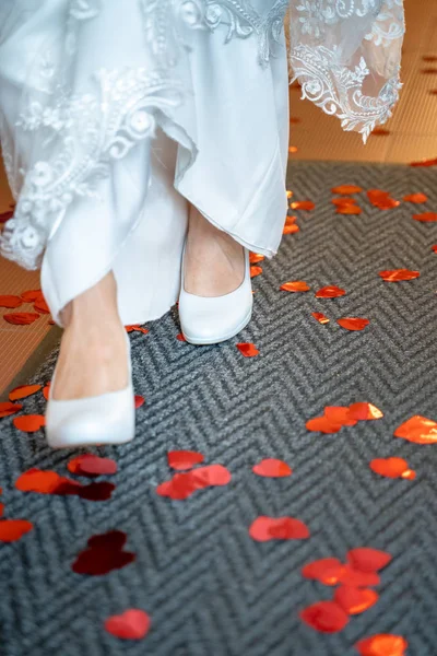 Chaussures de mariage blanches qui courent sur les cœurs rouges sur un coureur de porte — Photo