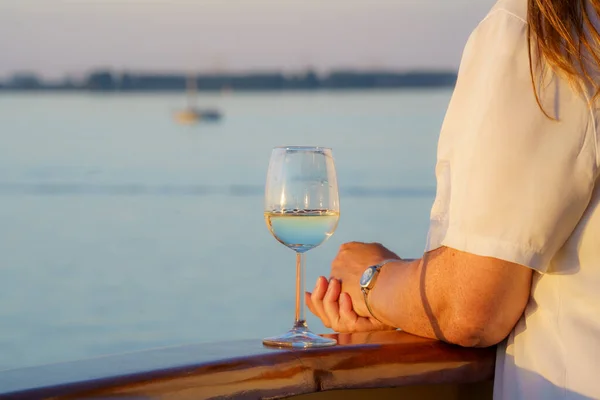 Luxury travel woman drinking wine on cruise ship at sunset