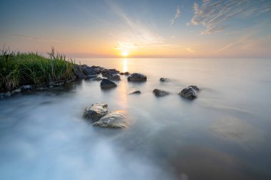 Hollanda 'nın IJsselmeer kıyısındaki eski Marken adasında gündoğumu.