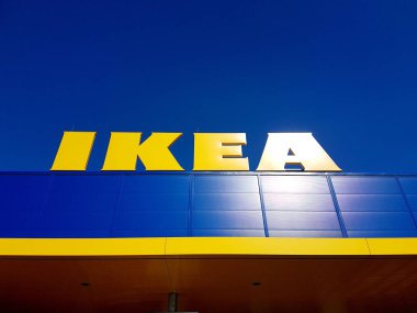 Riga, Letonya - 14 Nisan 2019. Yeni Ikea Mağazası, mavi gökyüzünde sarı Ikea Tabelası. Ikea dünyanın en büyük İsveç mobilya perakendecisi ve satıcısıdır.