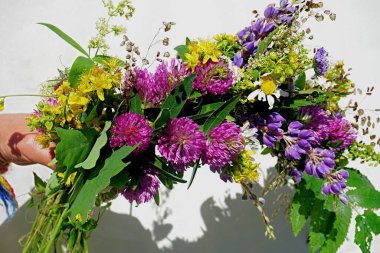 Yaz ortası meşesi ve çiçek çelengi sarı günbatımı ışığında. Eski Letonya kültür geleneği LIGO. Letonya 'da yaz dönümü kutlaması.