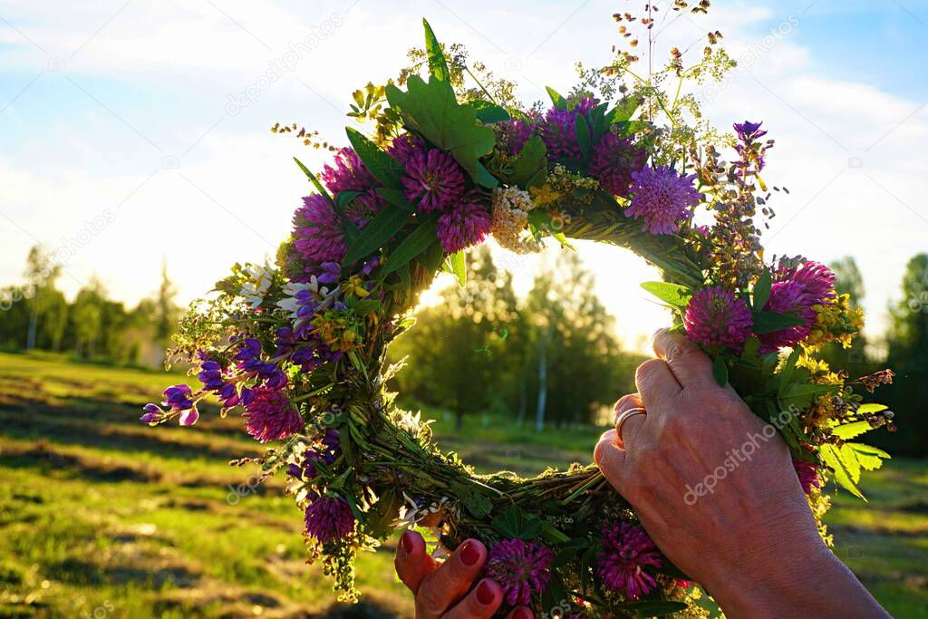 Midsummer Oak and flower wreath in yellow sunset light. Old Latvian culture tradition LIGO. Midsummer night celebrating in Latvia.