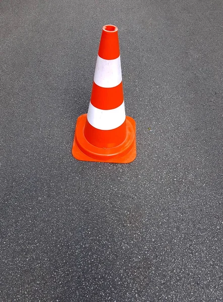 orange traffic cone placed in city street, warning sign on road, perfect asphalt background