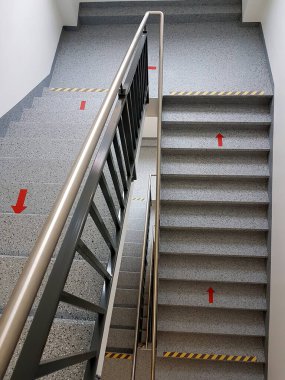 Çok katlı bir evin merdiven boşluğunda kırmızı ok işaretli, üst manzaralı.