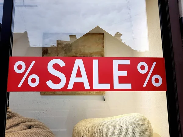 Sale sign on glass window shop.Shop window with sale sign on glass -% sale%