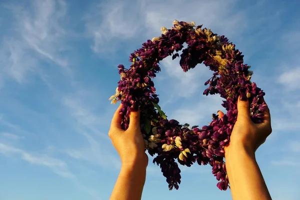 Corona Flores Rosadas Sobre Fondo Azul Cielo Manos Femeninas Sosteniendo —  Fotos de Stock