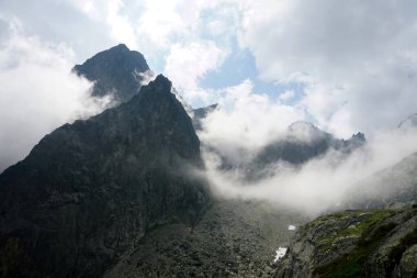                  Yüksek Tatra 'nın tepeleri beyaz bulutlarla dolu. Bulutlardaki dağlar. Slovakya 'daki Yüksek Tatras Dağları              