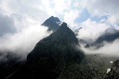                  Yüksek Tatra 'nın tepeleri beyaz bulutlarla dolu. Bulutlardaki dağlar. Slovakya 'daki Yüksek Tatras Dağları              