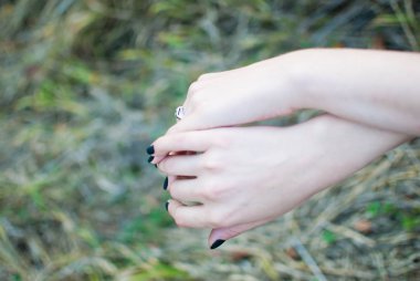 Kızın yumuşak ve hassas güzel elleri ile çim içinde belgili tanımlık geçmiş