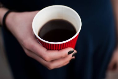 Kırmızı kağıt bardak kahve ile tutan kadın