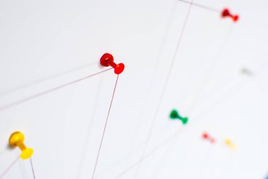 Arka plan. Ağ, sosyal medya, internet, takım çalışması, iletişim soyut soyut kavram (fikir). Renkli itme pimleri birlikte kırmızı iple bağlı. İzole. Bağlı kuruluşlar.