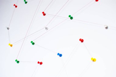 Arka plan. Ağ, sosyal medya, internet, takım çalışması, iletişim soyut soyut kavram (fikir). Renkli itme pimleri birlikte kırmızı iple bağlı. İzole. Bağlı kuruluşlar.