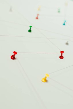 Arka plan. Ağ, sosyal medya, internet, takım çalışması, iletişim soyut soyut kavram (fikir). Renkli itme pimleri birlikte kırmızı iple bağlı. İzole. Bağlı kuruluşlar.