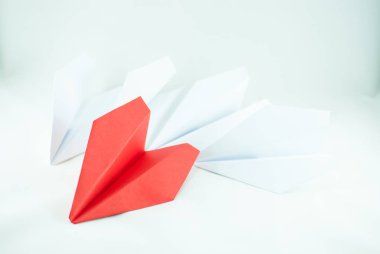 Kırmızı kağıt uçak izole beyaz bir arka plan üzerinde beyaz olanlar arasında. Konsept (fikir) havayolları, özgürlük, liderlik, başarı ve bireycilik.