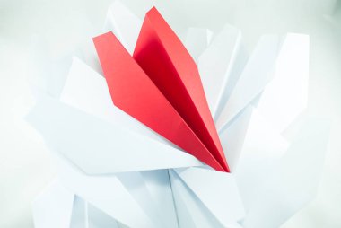 Kırmızı kağıt uçak izole beyaz bir arka plan üzerinde beyaz olanlar arasında. Konsept (fikir) havayolları, özgürlük, liderlik, başarı ve bireycilik.