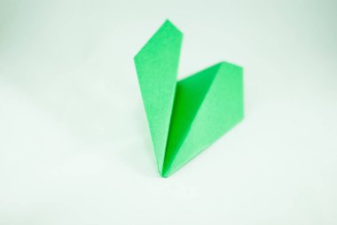 İzole bir beyaz zemin üzerine yeşil kağıt uçak. Konsept (fikir) havayolları, özgürlük, liderlik, ekoloji, başarı, sürdürülebilirlik ve yaratıcılık