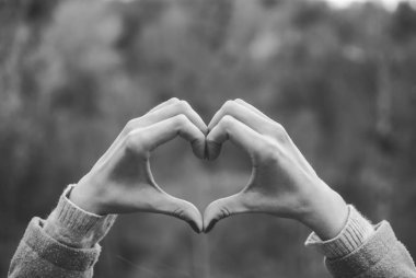 İhale kızın solgun eller bir kalp şekli jest şekillendirme. Konsept (fikir) aşk, dostluk, romantizm, tutku. Siyah ve beyaz.