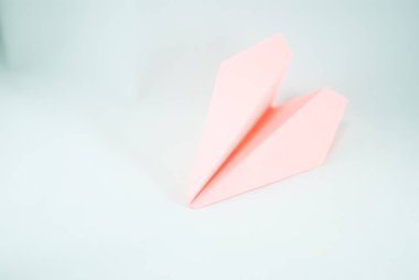 İzole beyaz bir arka plan üzerinde pembe (şeftali) kağıt uçak. Konsept (fikir) havayolları, özgürlük, liderlik, başarı ve yaratıcılık. Yakın çekim