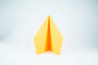 Beyaz bir arka planda, izole sarı kağıt uçak. Konsept (fikir) havayolları, özgürlük, liderlik, başarı ve yaratıcılık. Yakın çekim