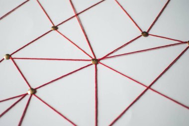 Arka plan. Soyut kavram (fikir) ağ, sosyal medya, internet, takım çalışması, iletişim. Raptiye kırmızı iple birbirine bağlı. İzole. Bağlı kuruluşlar.