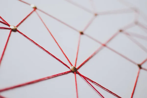 Linking entities. Network, networking, social media, connectivity, internet communication abstract. Web of red thread on white background.