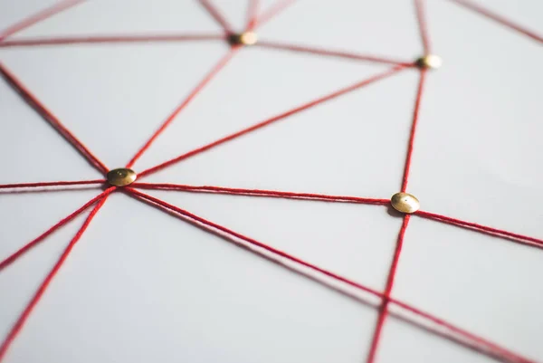 Background. Abstract concept (idea) of network, social media, internet, teamwork,  communication. Thumbtacks linked together by red thread. Isolated. Entities connected.