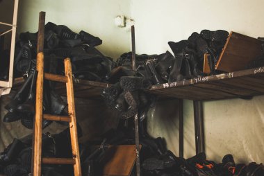 Acil servis botları çalışıyorum. Doğal felaketler, ekolojik felaketler, durumlarında kullanılan ağır siyah deri ayakkabı silahlı çatışmalar, yangınlar. Depolama birimindeki ahşap rafta duran çizmeler.