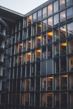 Bina akşam içinde ofiste çalışan insanlar. Modern mimarisi, Berlin, Almanya.