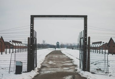 Oswiecim, Poland - February 16, 2018: One of the entrances to the Auschwitz concentration camp. Barbed wire fence clipart