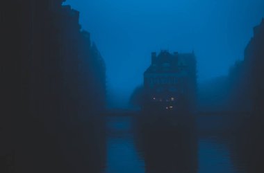 Speicherstadt, depo bölgesi Hafen Hamburg, Almanya şehirde ünlü Panoraması. Gölgeli kırmızı tuğla binalar ve kanal su kapsayan gri yoğun sis. Gotik görünümü