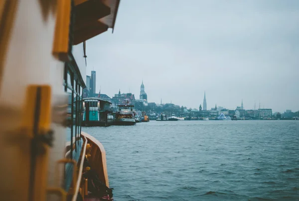 Cold tones of Hamburg city in winter. Cityscape and dark water of the sea. View from boat