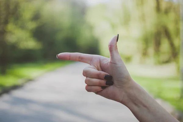 Meisje Maken Van Een Pistool Gebaar Tegen Zonnige Groene Achtergrond — Stockfoto